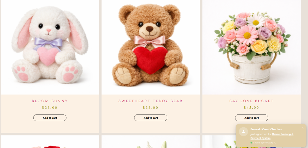 Gift Shop Product Grid Showing Bloom Bunny Plush, Sweetheart Teddy Bear, And Bay Love Bucket Floral Arrangement Priced $38–$45